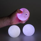 Echo glow juggling balls glowing, one in hand being squeezed